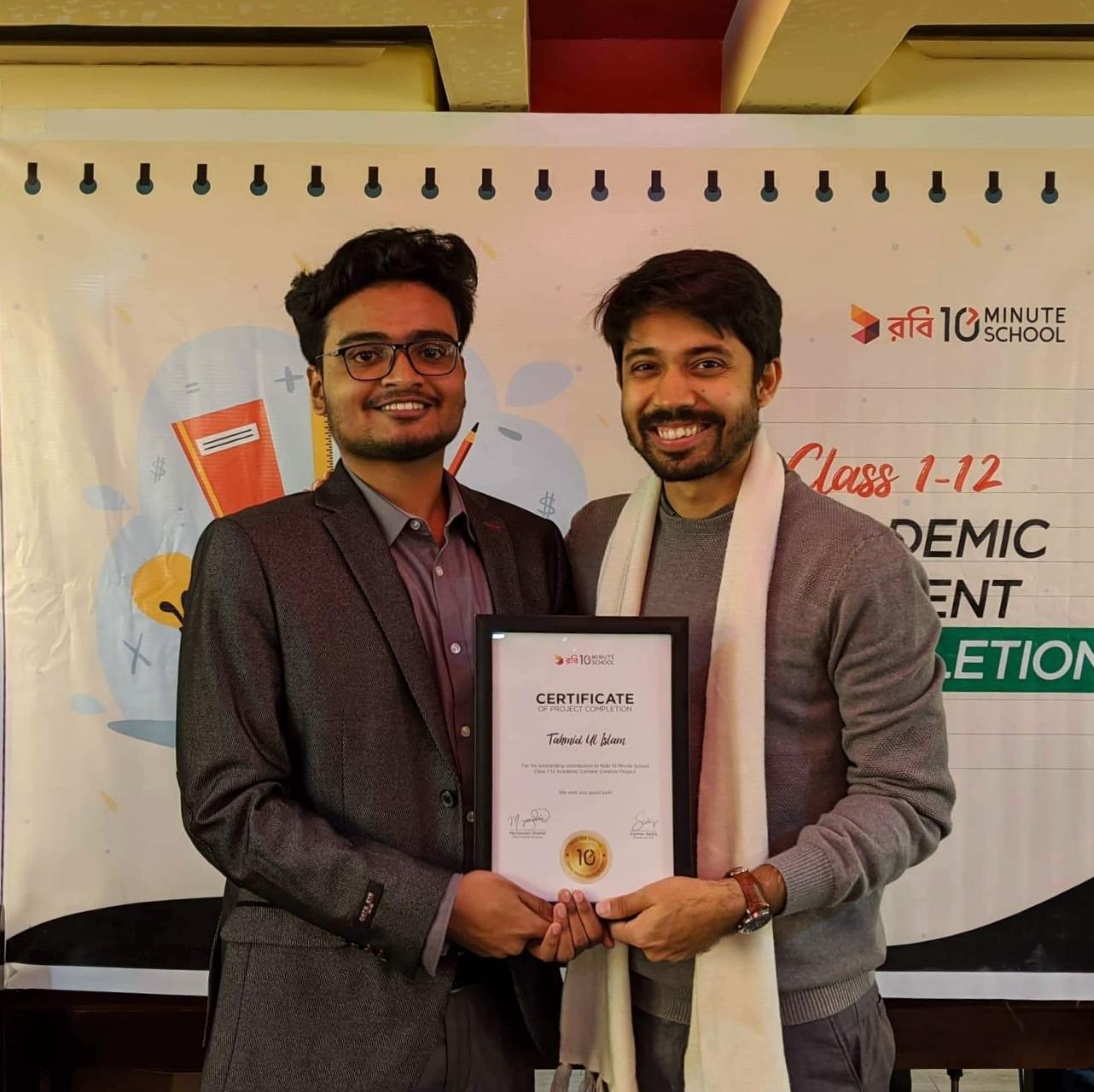 Tahmid Ul Islam receiving instructor recognition from Ayman Sadiq at 10 Minute School